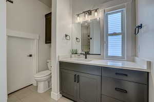 Bathroom featuring tile patterned flooring, vanity, and toilet