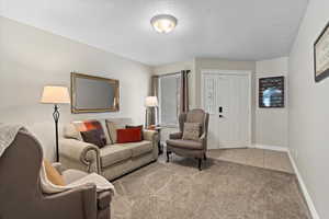 Living room with a textured ceiling and light colored carpet