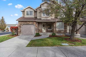 View of front of home with a front yard and a garage