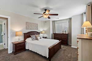 Carpeted bedroom with ceiling fan