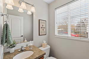 Bathroom with vanity, toilet, and a wealth of natural light