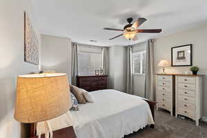 Carpeted bedroom featuring ceiling fan