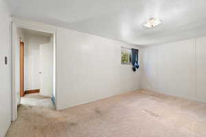 Carpeted spare room with a textured ceiling