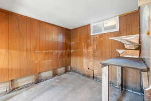 Spare room featuring concrete flooring and wooden walls