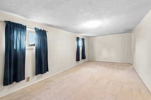 Spare room featuring carpet floors and a textured ceiling