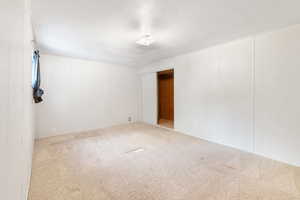 Carpeted empty room featuring a textured ceiling