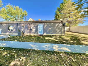 Back of house featuring a yard and central air condition unit