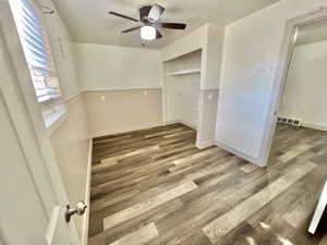 Empty room featuring ceiling fan, dark hardwood / wood-style flooring, and a textured ceiling