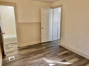 Unfurnished bedroom with dark hardwood / wood-style flooring