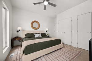 Bedroom with ceiling fan, carpet floors, and multiple windows