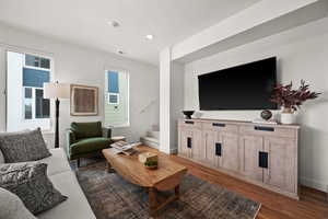 Living room featuring dark hardwood / wood-style flooring and a textured ceiling