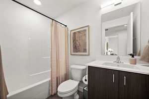 Full bathroom featuring vanity, shower / tub combo, and toilet