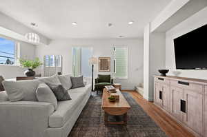 Living room featuring a textured ceiling and dark hardwood / wood-style flooring