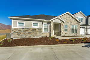 View of front of home with a mountain view, central AC, and a garage