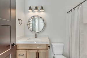 Bathroom featuring vanity, a shower with shower curtain, and toilet