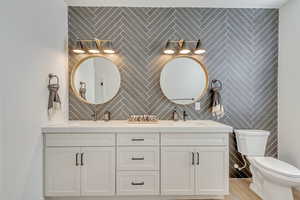 Bathroom with vanity, tile walls, and toilet