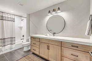 Full bathroom featuring tile patterned floors, vanity, shower / bath combo, and toilet