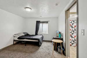 Bedroom with carpet flooring and a textured ceiling