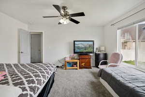 Carpeted bedroom featuring ceiling fan