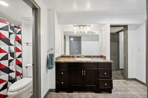 Bathroom with vanity, curtained shower, and toilet