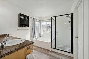 Bathroom featuring vanity, hardwood / wood-style flooring, and independent shower and bath