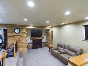 Living room featuring wood walls, carpet floors, and a textured ceiling