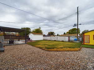 View of yard featuring a storage unit and a patio area