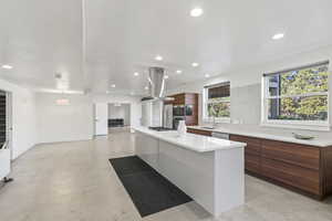 Kitchen featuring sink, stainless steel appliances, tasteful backsplash, a spacious island, and island range hood