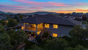 Back house at dusk with a mountain view and a balcony