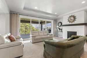 Living room with a raised ceiling and light hardwood / wood-style floors