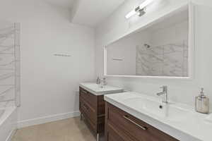 bathroom 2, basement, with double vanity and tiled shower / bath combo