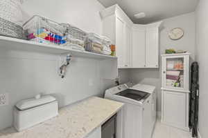 Laundry room featuring cabinets and independent washer and dryer