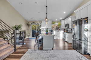 Kitchen with decorative backsplash, white cabinetry, a center island, and appliances with stainless steel finishes