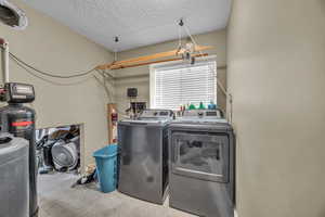 Laundry area with a textured ceiling and separate washer and dryer