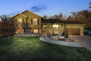 View of front of property featuring a yard and a garage