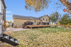 Back of property with a wooden deck and a yard