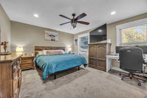 Carpeted bedroom with ceiling fan and cooling unit