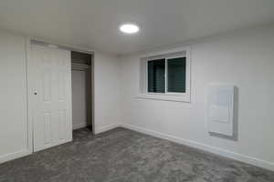 Unfurnished bedroom with a closet and dark carpet