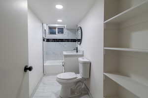 Basement -Full bathroom featuring vanity, toilet, and tiled shower / bath combo