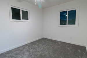 Carpeted empty room featuring ceiling fan