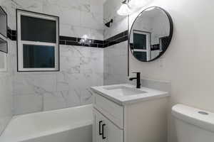 Full bathroom featuring vanity, tiled shower / bath, and toilet - Upstairs