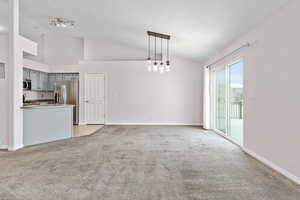 Living room with track lighting, light colored carpet, and high vaulted ceiling