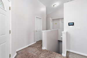 Corridor featuring lofted ceiling and carpet flooring