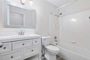 Full bathroom with shower / tub combination, vanity, hardwood / wood-style flooring, and toilet