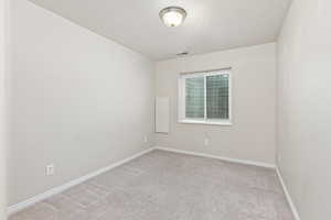 Carpeted empty room featuring a textured ceiling