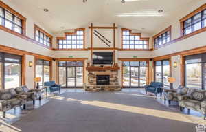 Living room featuring carpet flooring, high vaulted ceiling, and a healthy amount of sunlight