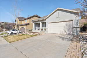 Traditional home featuring concrete driveway, stucco siding, a garage, and a shingled roof