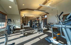 Workout area with ceiling fan and high vaulted ceiling