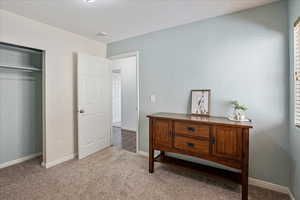 Carpeted bedroom featuring a closet and baseboards