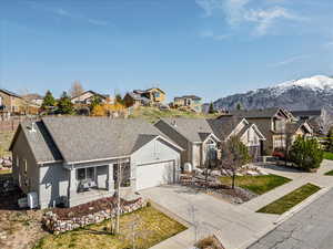 View of front facade featuring concrete driveway, a residential view, a garage, and stucco siding